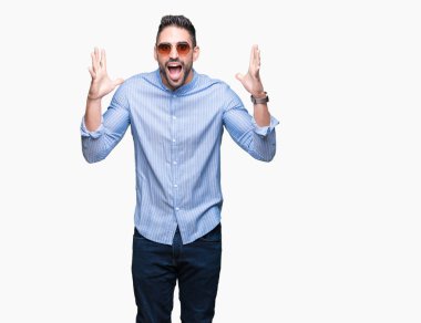 Yakışıklı delikanlı üzerinde güneş gözlüğü takıyor deli kutluyor arka plan izole ve silah ile başarı için yükseltilmiş ve açık gözleri heyecanlı çığlık hayrete düşürdü. Kazanan kavramı