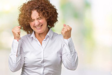 Gülümseyen ve başarı için çığlık güzel orta ager üst düzey businees kadın izole arka plan çok mutlu ve heyecanlı kaldırdı, silah ile kazanan jest yapıyor. Kutlama kavramı.