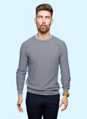 Çizgili süveter yapımı balık yüz dudaklı, çılgın ve komik bir jest giyen genç yakışıklı adam. Komik ifade.