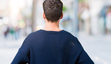 Geriye doğru uzakta silah ile vücut üzerinde seyir izole arka plan ayakta genç yakışıklı adam