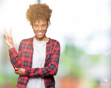 Mutlu yüz zafer işareti yaparken kameraya göz kırpıyor ile gülümseyen izole arka plan üzerinde gözlük güzel genç Afro-Amerikan kadın. İki numaralı.