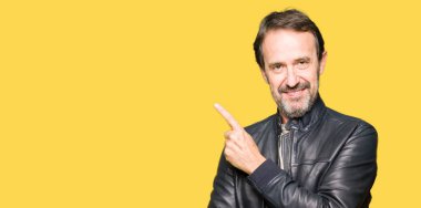 Siyah deri giyen orta yaş yakışıklı adam reklam, ciddi ve sakin yüz gösterilen yan el parmak ile işaret ceket