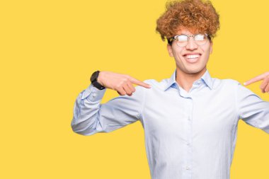 Genç yakışıklı iş adamı yüzünde gülümseme ile kendinden emin görünüyorsun, kendini gururlu ve mutlu parmakları ile işaret gözlüklü afro ile.