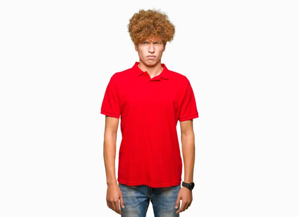 アフロの髪の問題のため身に着けている赤い シャツ懐疑論者と神経 しかめっ面の動揺のハンサムな青年 否定的な人 — ストック写真