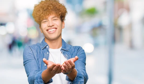 Jóképű Fiatalember Afro Haj Viselt Farmer Kabát Mosolyogva Kezet Tenyerével — Stock Fotó