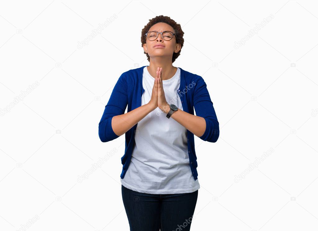 Young beautiful african american woman wearing glasses over isolated background begging and praying with hands together with hope expression on face very emotional and worried. Asking for forgiveness. Religion concept.