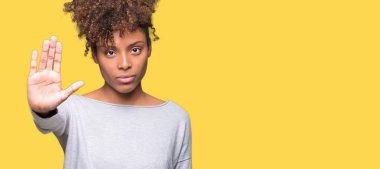 İzole arka stop yapıyor güzel genç Afro-Amerikan kadın elin avuç ile şarkı. Negatif ve ciddi bir jest yüz ifadesiyle uyarı.