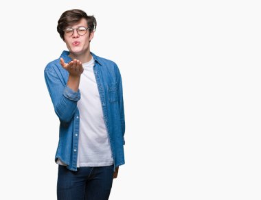 Bir öpücük el ile güzel ve seksi olmak hava üfleme kamera bakarak izole arka plan üzerinde gözlük takan yakışıklı delikanlı. Aşk ifade.