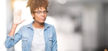 İzole arka plan Waiving mutlu selam söyleyerek üzerinde gözlük ve gülümseyen, dostça karşılama jest giyen güzel genç Afro-Amerikan kadın