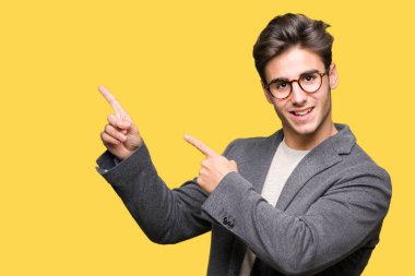 Gülümseyen ve iki elleri ve parmakları ile tarafına işaret kamera bakarak izole arka plan üzerinde gözlük takan genç iş adamı.