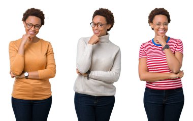 Afro saç ile genç Afrikalı Amerikan kadın gözlük giyerek kamera emin görünümlü, çapraz silah ve el çene üzerinde yükseltilmiş ile gülümseme ile. Pozitif düşünme.