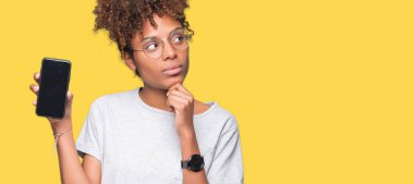 Smartphone ekran izole arka plan ciddi bir yüz düşünme hakkında soru, çok karışık bir fikir üzerinde gösterilen genç Afro-Amerikan kadın