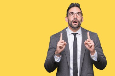 Genç yakışıklı iş adamı izole arka plan üzerinden hayran ve yukarıya bakıp parmakları ile işaret şaşırttı ve silah kaldırdı.