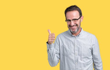 Hareketi el ile mutlu yaşasın yapıyor izole arka plan üzerinde gözlük takan yakışıklı orta yaş zarif komuta sizde. Başarı gösteren kameraya bakarak ifade onaylama.