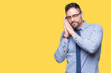 Uyku yorgun hayal ve ellerle birlikte poz ile kapalı gözler gülümseyen izole arka plan üzerinde gözlük takan genç iş adamı.