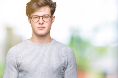 Yüzünde ciddi bir ifade ile izole arka plan üzerinde gözlük takan yakışıklı delikanlı. Basit ve doğal kameraya bakıyor.