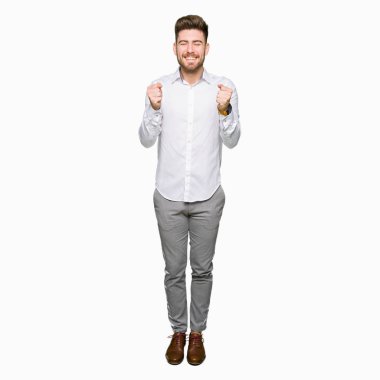 Genç yakışıklı iş adamı silah ile başarı için heyecanlı zafer kutluyor gülümseyen kaldırdı. Kazanan kavramı.