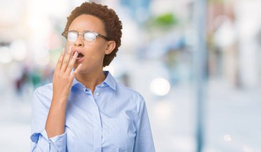 Genç güzel Afro-Amerikan iş kadını izole arka plan üzerinde esneme yorgun kapsayan ağız el ile sıkılmış. Restless ve uyku hali.