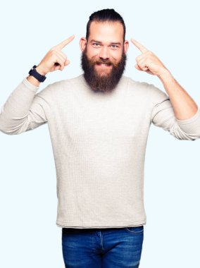 Her iki el parmağı, harika bir fikir ile baş gösteren gülümseyen ya da düşünce rahat kazak giyen genç sarışın adam, iyi hafıza