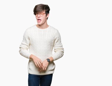 Seksi bir ifadeyle, neşeli ve mutlu yüzünü kameraya bakarak göz kırpıyor izole arka plan üzerinde gözlük takan genç yakışıklı adam.