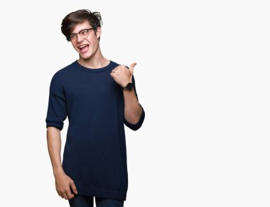 Seyir ve başparmak yanında yukarıyı mutlu yüz ile gülümseyen izole arka plan üzerinde gözlük takan genç yakışıklı adam.