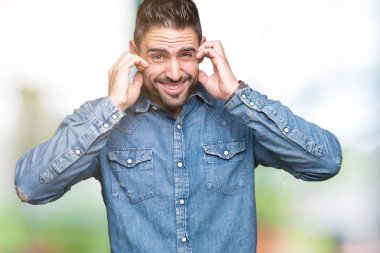 Yüksek sesle müzik gürültü rahatsız ifade parmaklarıyla kulaklarıyla kapsayan izole arka plan üzerinde genç yakışıklı adam. Sağır kavramı.