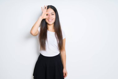 Gülümseyen, parmakları ile mutlu yüz üzerinden seyir göz el ile ok jest yapıyor izole arka plan güzel esmer kadın.
