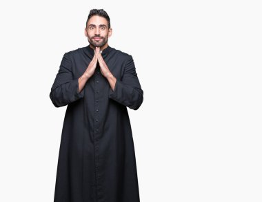 Genç Hıristiyan rahip ellerle birlikte AF emin gülümseyen için soran dua izole arka plan üzerinde.