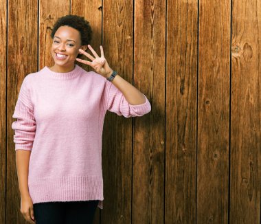 Güzel genç Afro-Amerikan kadın gösterilen ve parmakları ile işaret izole arka plan yüzünden kendinden emin ve mutlu gülümseyerek süre dört numara.