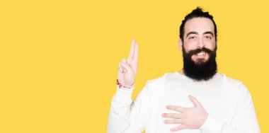 Uzun saç ve sakal sportif sweatshirt giyen genç hipster adamla göğüs ve bir sadakat sözü yemin yapma parmaklar, el ile küfür