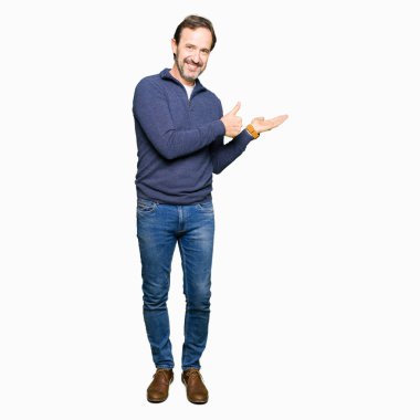 Bir kazak gösteren palm el giyen ve yukarıya, mutlu ve neşeli gülümseyen baş parmakları Tamam jest yapıyor orta yaş yakışıklı adam