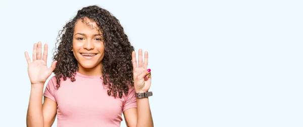 Joven Hermosa Mujer Con Pelo Rizado Con Camiseta Rosa Mostrando — Foto de Stock