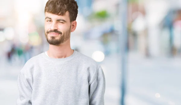 Joven Hombre Guapo Con Sudadera Sobre Fondo Aislado Guiño Mirando —  Fotos de Stock