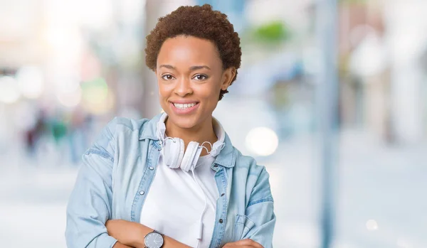 年轻的非洲裔美国妇女戴着耳机在孤立的背景快乐的脸微笑着交叉双臂看着镜头 积极的人 — 图库照片