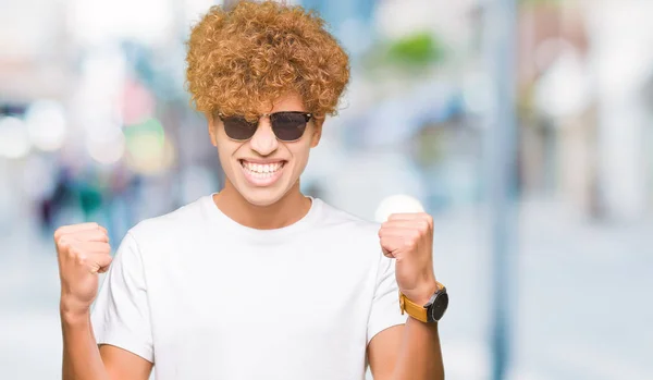 Ung Vacker Man Med Afro Hår Bär Solglasögon Firar Överraskad — Stockfoto