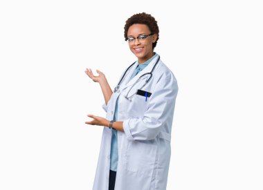 Açık el ile doğal gülümseyen girmek için izole arka plan davet üzerine tıbbi ceket giyen genç Afro-Amerikan doktor kadın