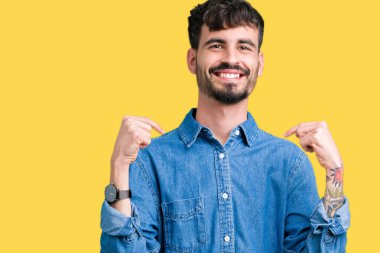 Yüzünde gülümseme ile kendinden emin görünüyorsun, kendini gururlu ve mutlu parmakları ile işaret izole arka plan üzerinde genç yakışıklı adam.