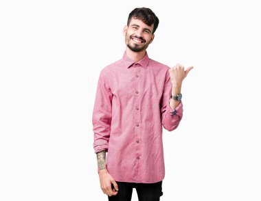 Yakışıklı delikanlı arıyor ve başparmak yanında yukarıyı mutlu yüz ile gülümseyen izole arka plan üzerinde pembe gömlek giymiş.