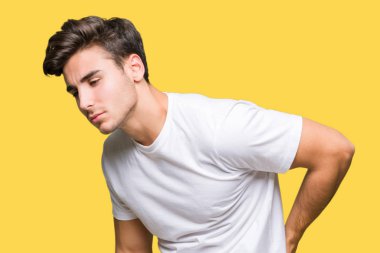 Beyaz t-shirt üzerinde izole giyen genç yakışıklı adam arka plan geri el ile kas ağrısı dokunmadan acı sırt ağrısı,