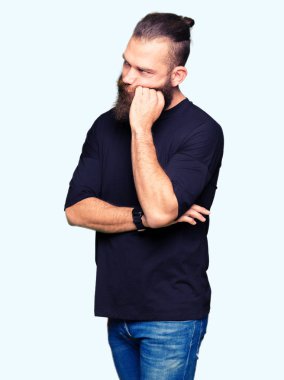 Rahat t-shirt düşünme seyir giyen genç sarışın adam yorgun ve sıkılmış çapraz silah depresyon sorunları ile.