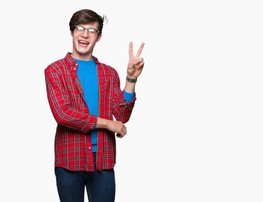 Mutlu yüz zafer işareti yaparken kameraya göz kırpıyor ile gülümseyen izole arka plan üzerinde gözlük takan genç yakışıklı öğrenci adam. İki numaralı.