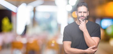 Yakışıklı delikanlı emin çapraz kollar ve çeneme kaldırdı el ile gülümseme ile kameraya bakarak izole arka plan üzerinde. Pozitif düşünce.