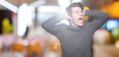 İzole arka plan üzerinde genç yakışıklı zarif adam çılgın ve baş elleri ile korkuyor, korkmuş ve açık ağız ile şok şaşırttı