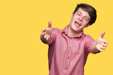 Genç yakışıklı iş adamı sarılmak için kollarını açarak gülümseyerek kameraya bakarak izole arka plan üzerinde. Neşeli ifade kucaklayan mutluluk.