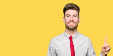 Ve parmak gülümseyen süre bir numara ile kendinden emin ve mutlu yukarıyı gösteren genç yakışıklı iş adamı.