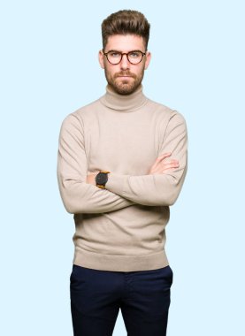 Yüz çapraz kolları üzerinde gözlük şüpheci ve sinir, onaylamayan ifade giyen genç yakışıklı iş adam. Negatif kişi.