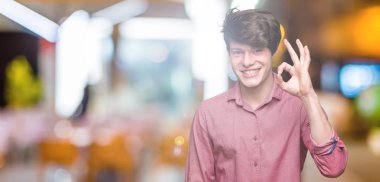 Genç yakışıklı iş adamı izole arka plan el ve parmaklar ok işaretiyle yapıyor olumlu gülümseyen üzerinde. Başarılı ifade.