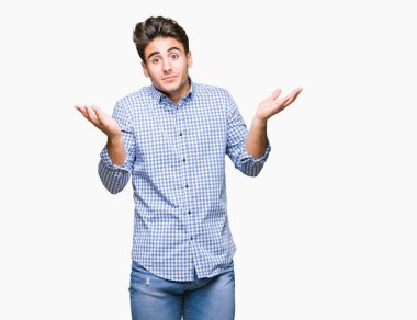 Genç yakışıklı iş adamı izole arka plan clueless ve şaşkın bir ifadeyle kollar ve eller ortaya çıkar üzerinden. Şüphe kavramı.