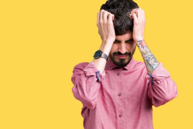 Genç yakışıklı adam giymiş pembe gömlek çünkü umutsuz ve stresli baş ağrısı acı izole arka plan üzerinde ağrı ve migren. Ellerini kafasına.