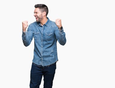 Soyutlanmış, mutlu ve heyecanlı genç bir adam kollarını kaldırmış, gülümseyen ve başarı için çığlık atan kazanan bir jest yapıyor. Kutlama konsepti.